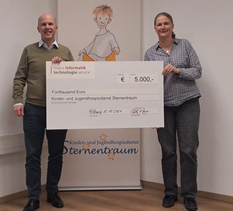 Geschäftsführer Christoph Röger und Kinder- und Jugendhospizdienstleiterin Kirsten Allgayer mit großem Scheck vor dem Sternentraumbanner mit dem Schriftzug des KJHD und dem Sternenkind