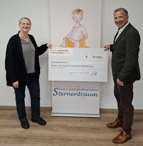 FI-TS Das Bild zeigt zwei Personen, eine Frau links und einen Mann rechts, die einen überdimensionalen Scheck halten. Der Scheck ist ausgestellt von