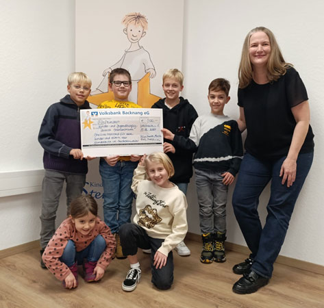 Kinder übergeben an Kirsten Allgayer einen großen Scheck